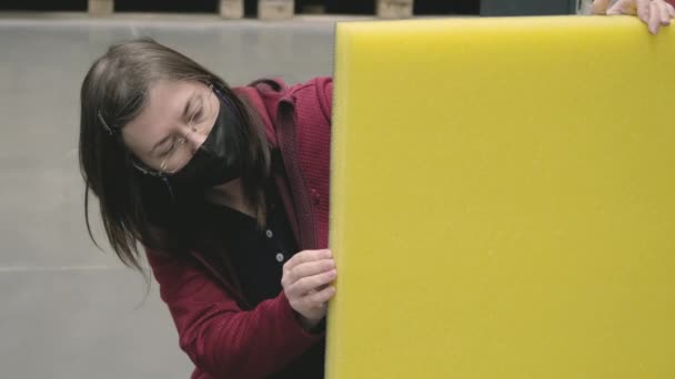 Frau im Baustoffgeschäft kauft gelbe, schalldichte Dämmung — Stockvideo