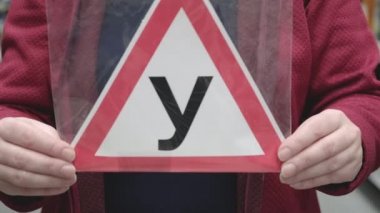 Kız Rus mektubunu elinde tutuyor. Tecrübesiz sürücünün sürdüğü uyarısı