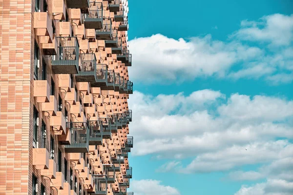 Parte de la fachada de una casa roja, alicatada y moderna. Cielo azul, nubes blancas —  Fotos de Stock