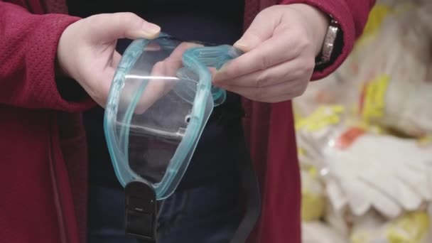 Kobieta w sklepie z materiałami budowlanymi wybiera do zakupu okulary ochronne z tworzywa sztucznego — Wideo stockowe