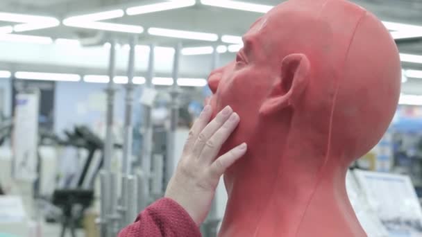 Woman in store chooses to buy red boxing mannequin in form of man. Hand close up — Stock Video