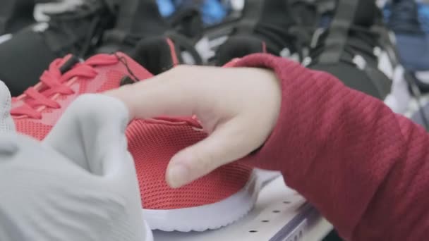 Žena v obchodě s obuví se rozhodne koupit, červené sportovní tenisky v síťce pro chůzi — Stock video