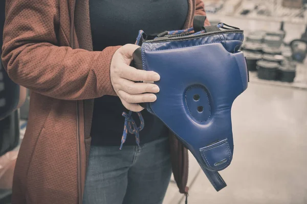 Kvinna i butik väljer att köpa blå hjälm för att skydda huvudet under boxning — Stockfoto