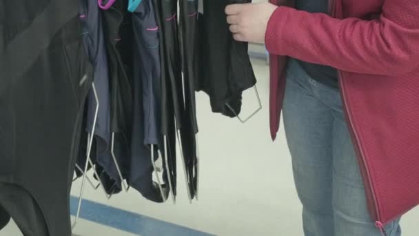 Mujer caucásica con sobrepeso elige un traje de baño negro cerrado para comprar en una tienda — Vídeo de stock