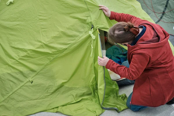Woman in mask against virus buy tent in store for tourism and outdoor activities