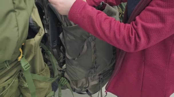 Woman in a store buys a tourist backpack for extreme hiking — Stock Video