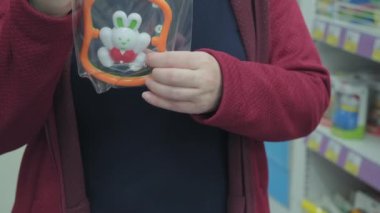 Hamile kız, doğmamış bebek için tavşan şeklinde bir çıngırak seçiyor.