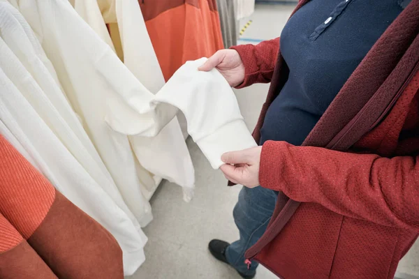 Mulher com excesso de peso compra uma camisola branca em uma loja. Mãos ao alto — Fotografia de Stock