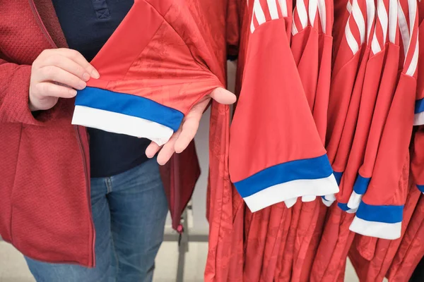 Mulher na loja escolhe camisa para esportes com impressão de bandeira da Federação Russa — Fotografia de Stock