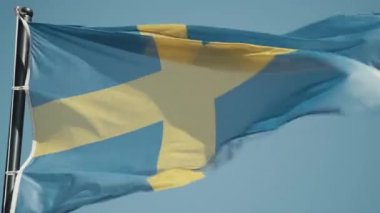 İsveç 'in mavi bayrağı ve rüzgarda dalgalanan sarı bir haç. Yakın çekim.