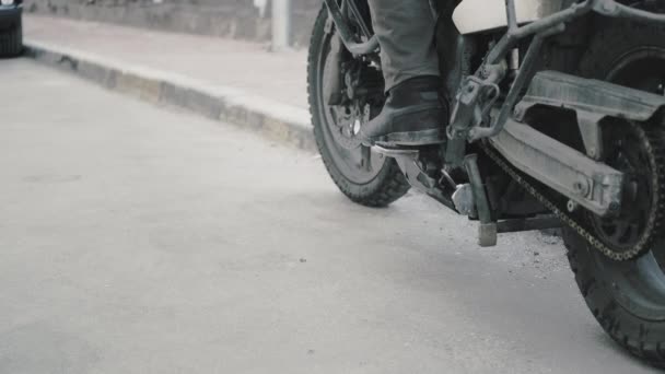 Motocyklista umieszcza stopę na motocyklu enduro i wysiada z pojazdu — Wideo stockowe