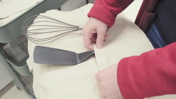 Girl in the store chooses a sturdy bag for storing kitchen utensils and cutlery — Stock Video