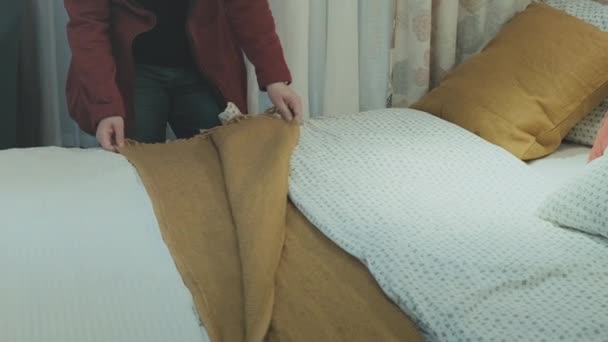 Кавказька жінка з магазину купує нове лляне ліжко. — стокове відео