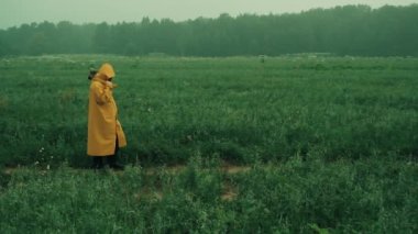 Maniac in a yellow raincoat throws an axe at a fleeing woman in a blue raincoat