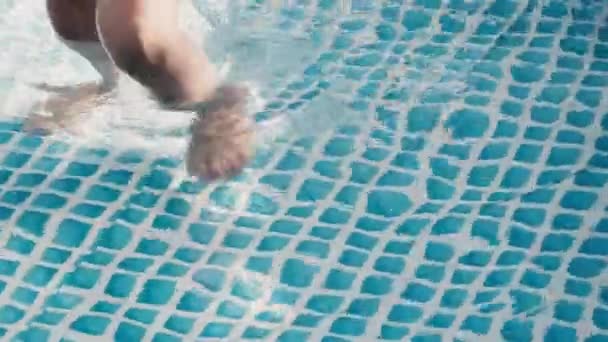 Jambes d'enfants dans une piscine gonflable. Le gamin joue avec le canard jaune en caoutchouc — Video