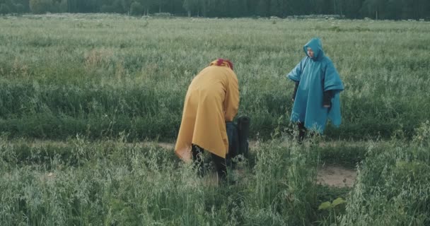 L'homme et la femme sont des randonneurs marchant le long de la route de campagne boire du flacon à vide — Video