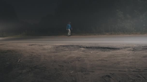 L'homme au chapeau de cow-boy marche le long d'une route brumeuse. Concept de voyage — Video