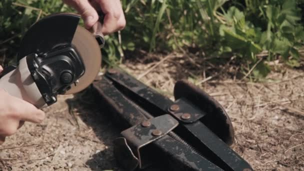 Man zaagt een handvat voor het optillen van krik met een cirkelzaag. Handen van dichtbij. — Stockvideo