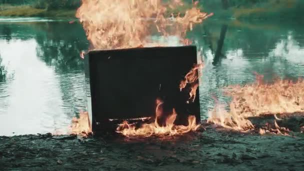 Vieille télévision vintage brûle de feu près de l'eau. L'eau brûle aussi — Video