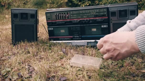 Man neemt tape cassette uit de kast plaatst het in tape oude retro recorder — Stockvideo