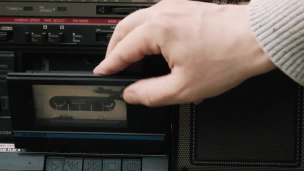 Muž vloží filmovou kazetu do starého, retro magnetofonu. Zavřít snímek — Stock video