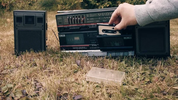 Człowiek bierze kasetę magnetofonową z futerału wkłada ją do starego magnetofonu retro — Zdjęcie stockowe