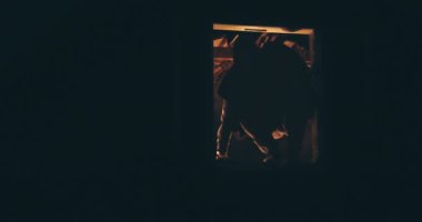 Katil hırsız evin penceresinde elinde bıçakla karanlıkta saklanıyor.