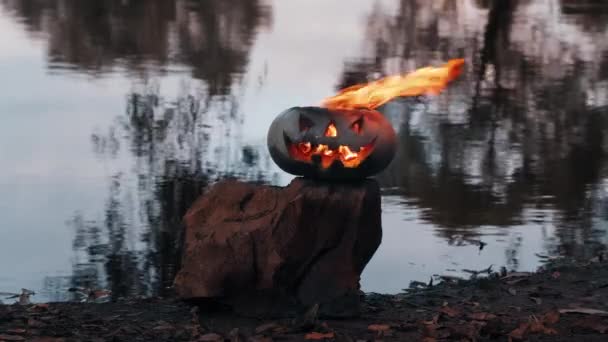 Halloween. Calabaza en el fondo del estanque, brilla, llama ardiente arde dentro de ella — Vídeo de stock