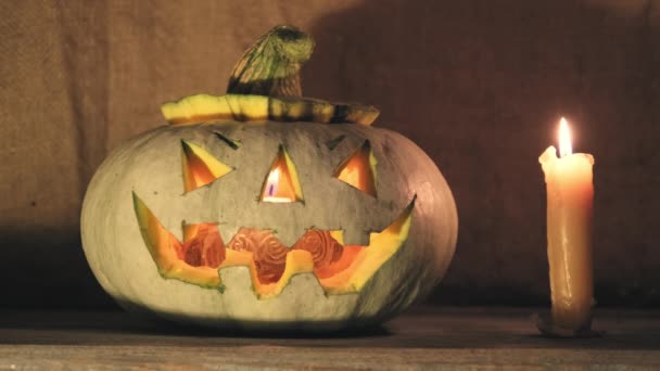 Tökfej Halloweenre ijesztő arccal egy fából készült verandán. — Stock videók