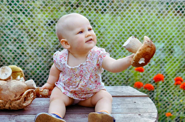 Niña en la mesa de madera con setas blancas —  Fotos de Stock