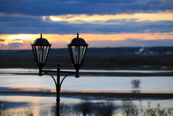 old-fashioned street lidgts on the river bank at sunrise