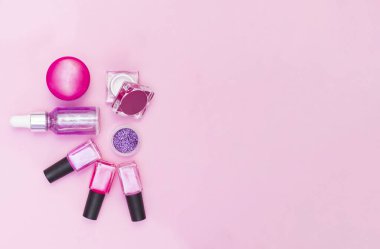 Pembe ve mor arka planda manikür ve pedikür için kozmetik seti. Jel cilası, tırnak törpüsü, tırnak makası, satıcı, üst manzara. Metin için yeri olan bir kartpostal kompozisyonu