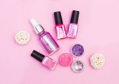 Manikür, pedikür malzemelerinin üst görüntüsü, pembe arka planda.