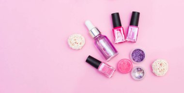 Manikür, pedikür malzemelerinin üst görüntüsü, pembe arka planda.