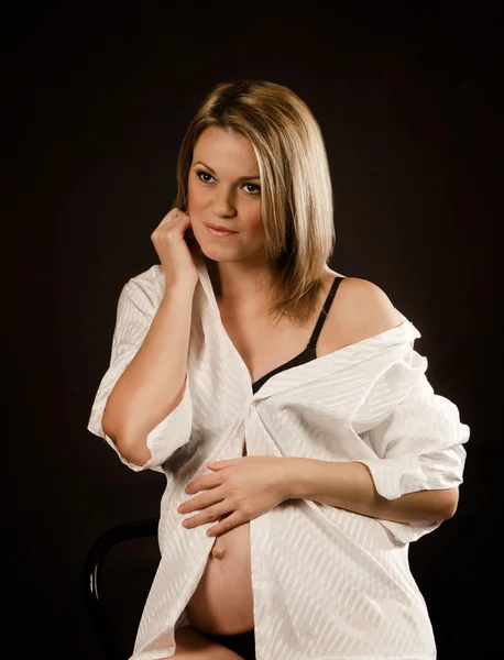 Беременная женщина в белой рубашке — стоковое фото