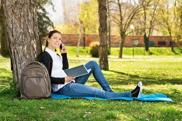 Student prata i telefon i en park — Stockfoto