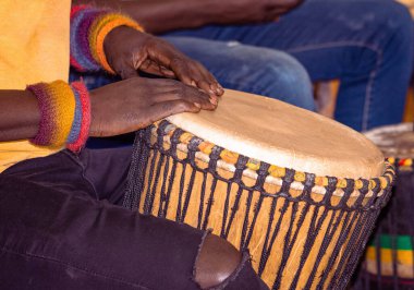 Afrikalı bir djembe bateristin yakın çekimi. Baterist Afrika perküsyon müziği çalıyor. Etnik perküsyon müzik aleti Djembe ve erkek eli. Afrika 'nın ritmi.