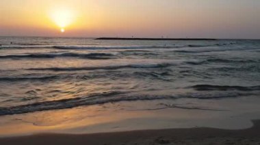 Gün batımında sakin dalgalar alçak bir bakış açısından. İsrail, Tel Aviv 'deki Akdeniz' de gün batımı. İsrail sahilinde gün batımı.