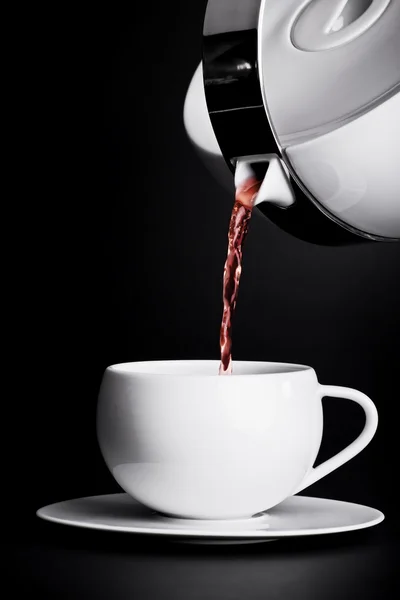 Pouring tea on black background — Stock Photo, Image