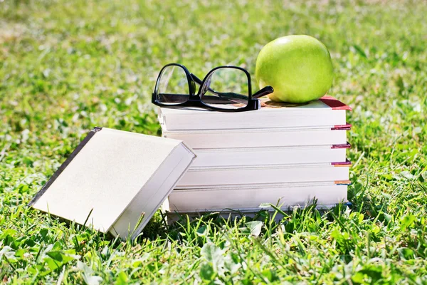 Bog sæt, briller og æble - Stock-foto
