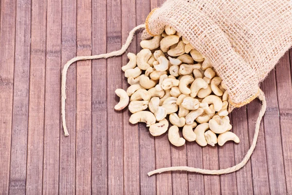 Gemorste cashewnoten op houten achtergrond — Stockfoto