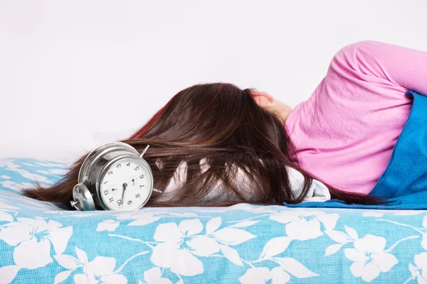 Giovane ragazza che dorme mentre l'orologio squilla — Foto Stock