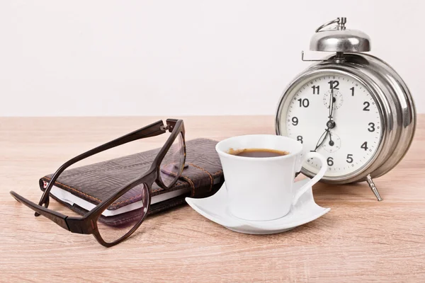 Glasögon, notebook, väckarklocka och kaffekopp — Stockfoto