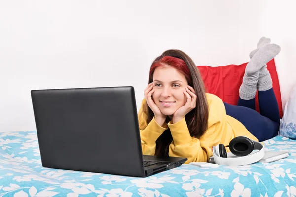 Young girl in her room watching something on her laptop — Stok fotoğraf