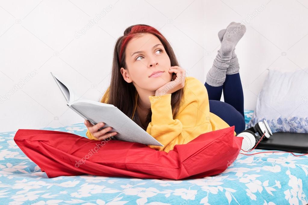 Young girl dream-reading on her bed