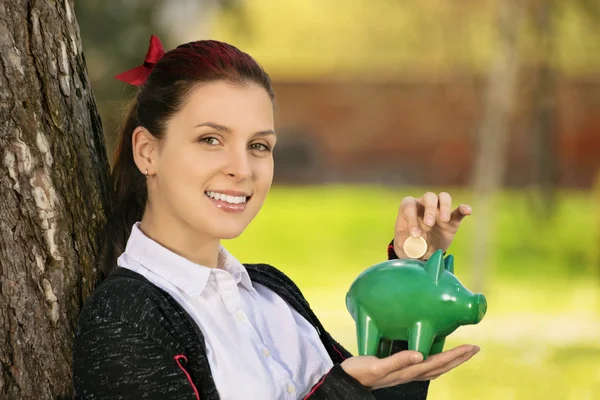 Chica joven sosteniendo una alcancía — Foto de Stock