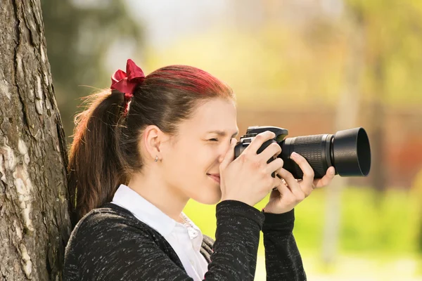 Menina jovem atirando sua câmera — Fotografia de Stock