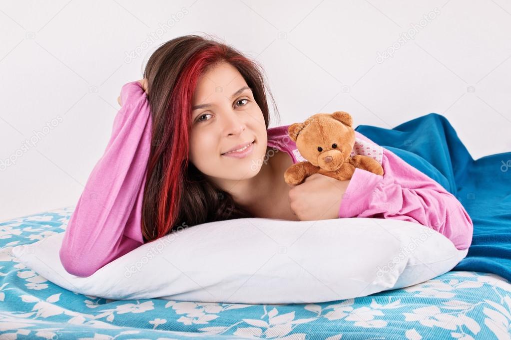 Young girl waking up with her teddy bear