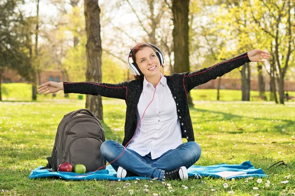 Étudiante dans un parc les bras tendus comme si elle volait — Photo