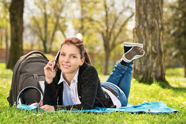 Student i en park som talar i telefon — Stockfoto